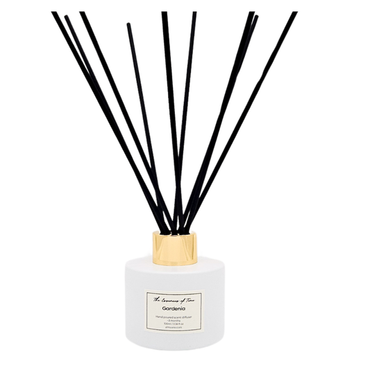 Gardenia scented reed diffuser in white glass jar with black fiber reeds.