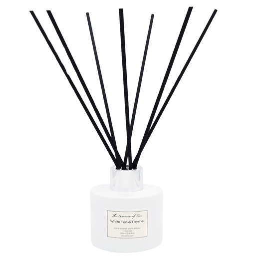 White Tea and Thyme scented diffuser in a white glass jar with black fiber reeds.