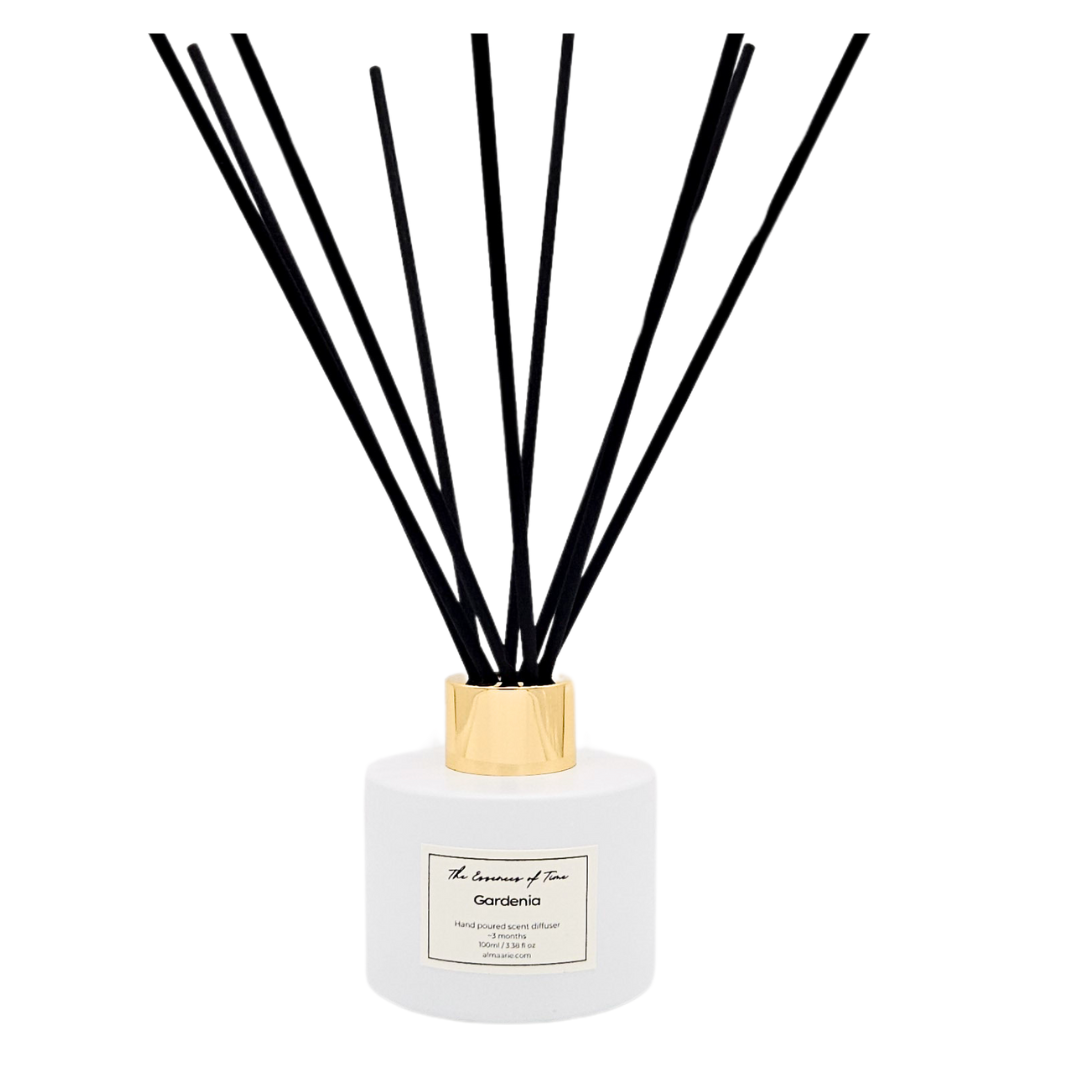 Gardenia scented reed diffuser in white glass jar with black fiber reeds.