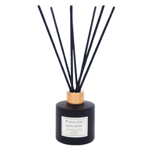 Ombre Leather scented reed diffuser in black glass jar with rose gold cap and black fibre reeds for home fragrance.