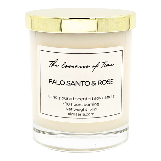 Palo Santo and Rose scented soy candle in a clear lass jar with golden dust cover.